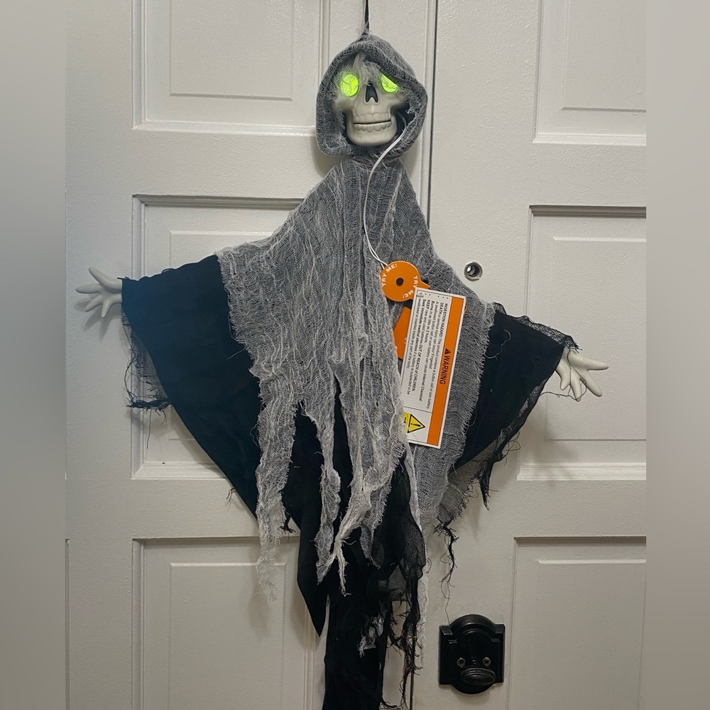 This is a hanging grim reaper or skeleton ghost Halloween decoration.